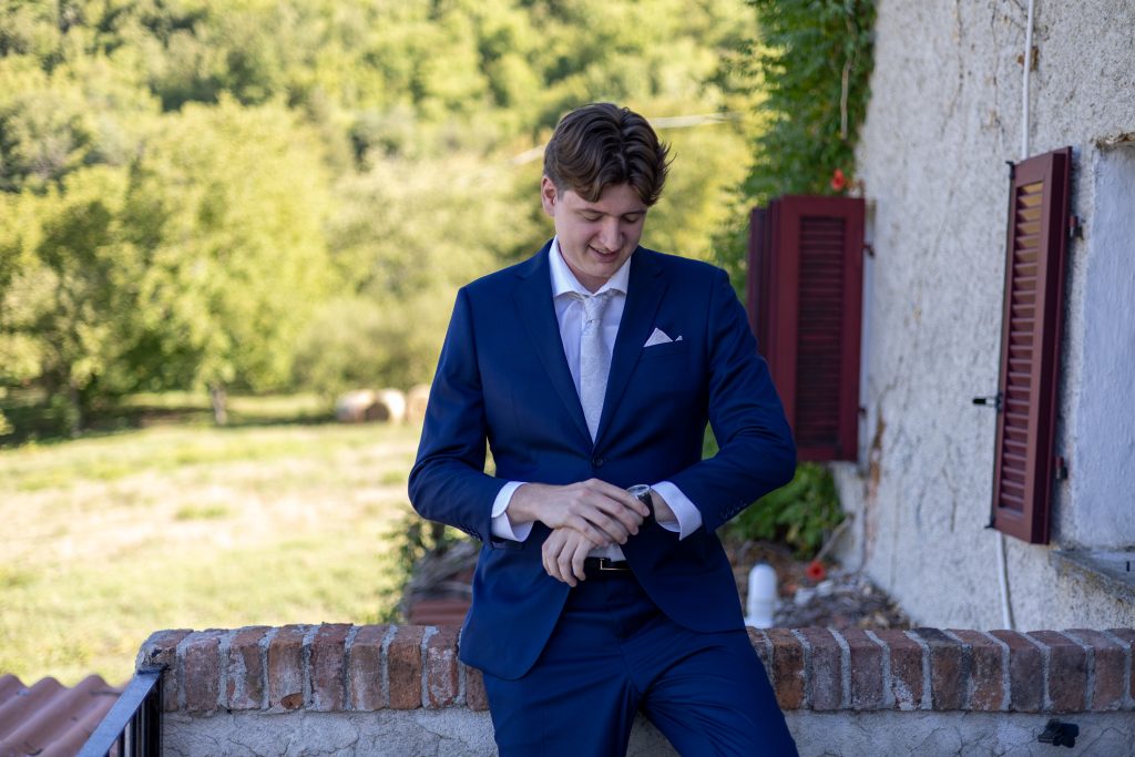 Model in een blauw trouwpak op de binnenplaats in Piemonte