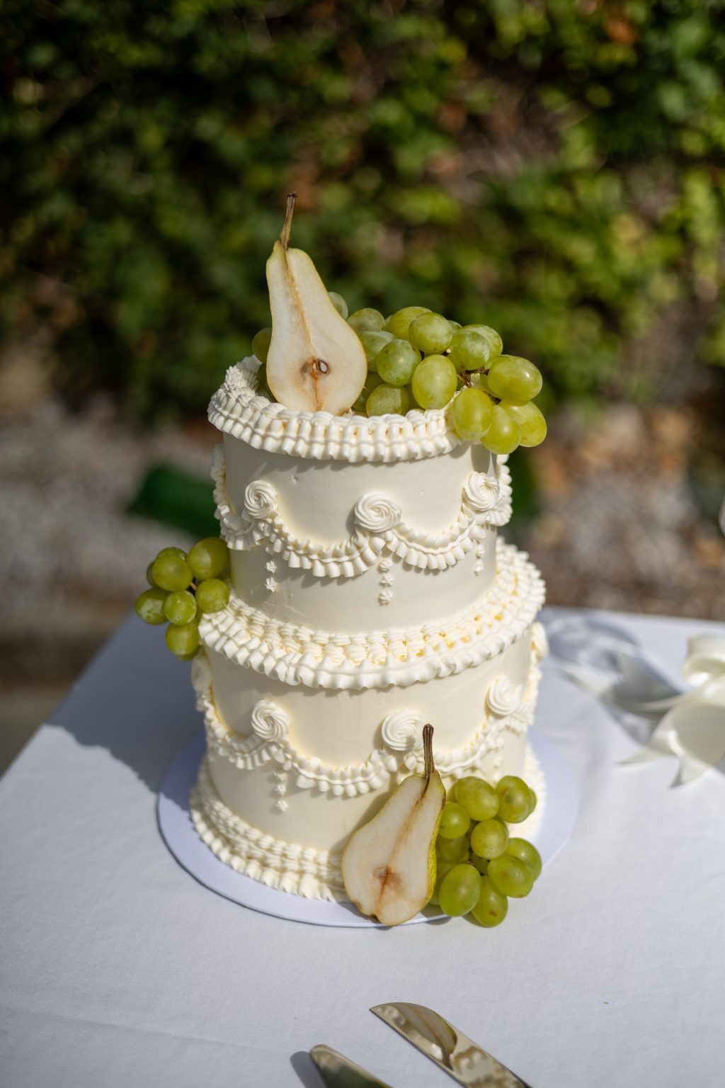 Witte bruidstaart met groene details bij de styled shoot in Italië