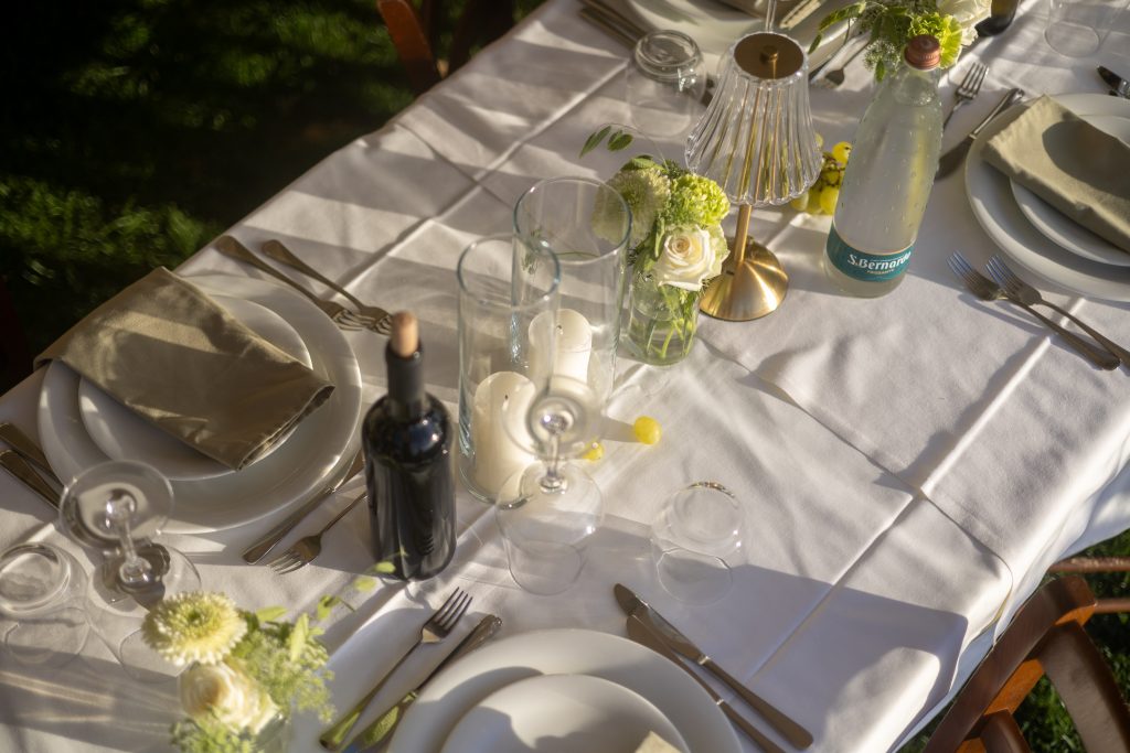 Servies, glazen, stationery en groene details op een gedekte tafel in Piemonte