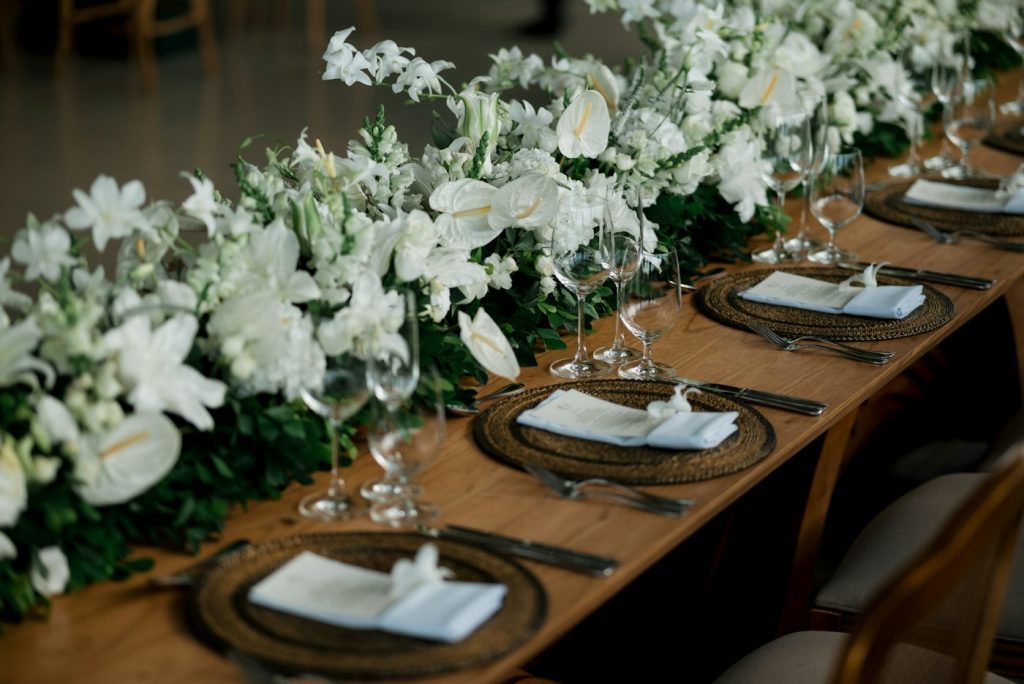 Sfeerbeeld van een gestylde trouwtafel met witte bloemen en servies